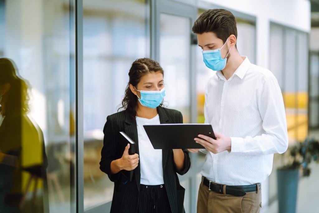 Two manager in protective face masks having an argument discussing business Issue. Covid-19.